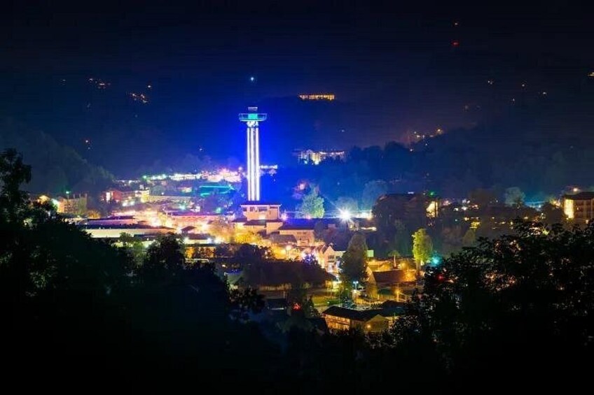Paesaggio urbano notturno con edifici illuminati e una torre imponente. 2