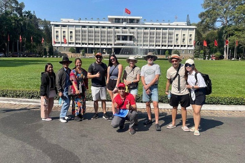 Un grupo de personas de pie frente a un edificio con una fuente. 4