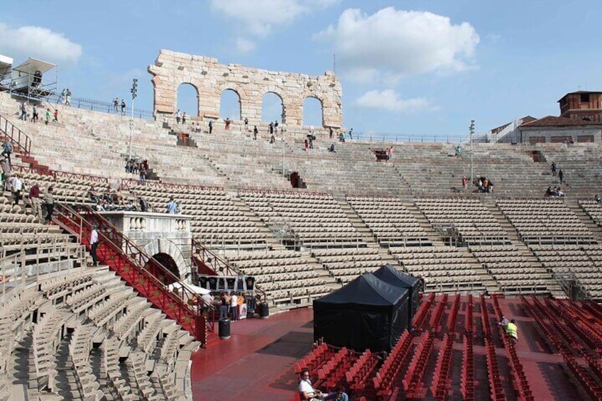 An ancient amphitheater with stone seating and a central stage. 3