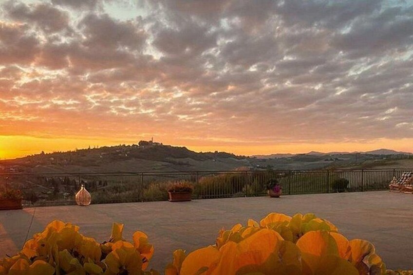 Un atardecer sobre un paisaje montañoso con una cerca y macetas. 3