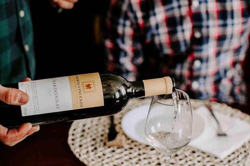 Una persona sirve vino de una botella en una copa. 4