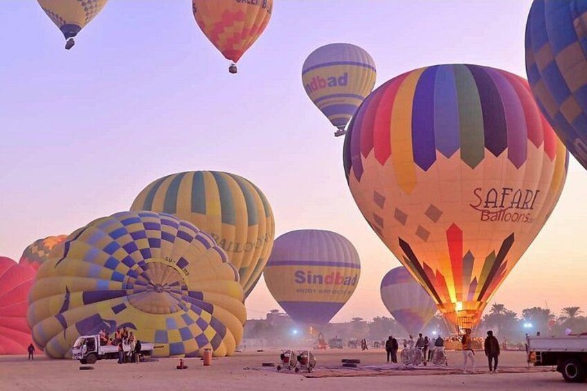 A group of hot air balloons at sunset with the words 'SAFARI Balloons' and 'Sindbad' visible on some balloons. 5