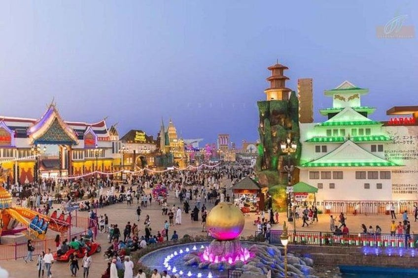 A bustling square with traditional architecture, a large illuminated sphere, and a fountain. 4