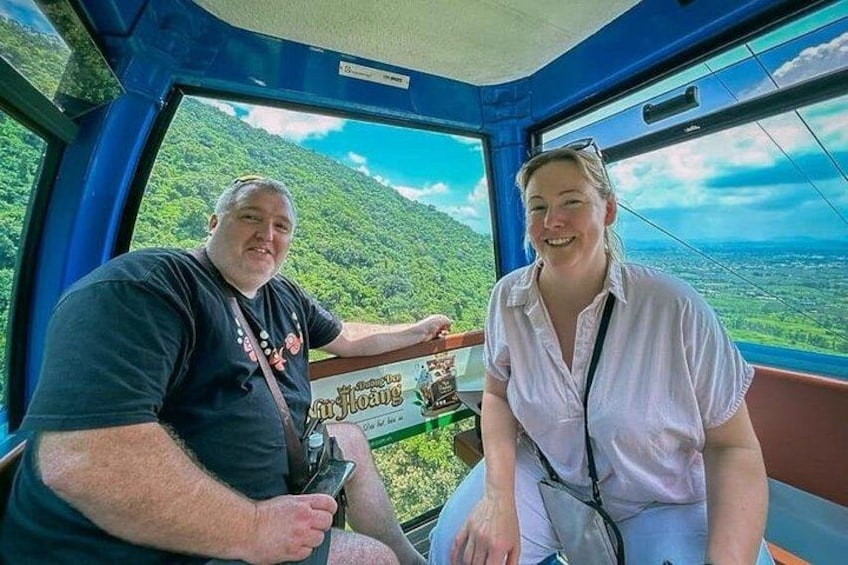 Two people seated inside a vehicle with a scenic view of a mountainous landscape. 1