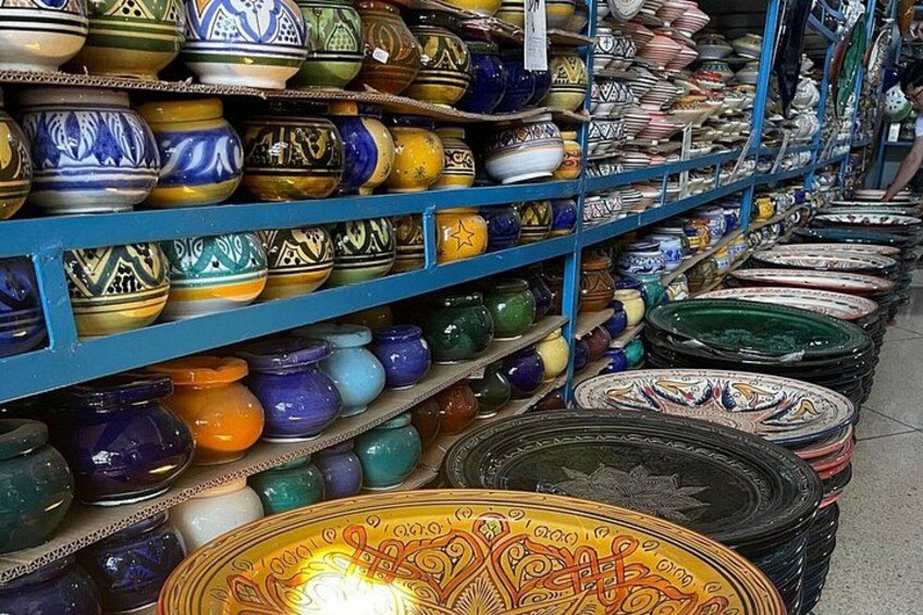 A variety of colorful ceramic bowls and plates on shelves. 3