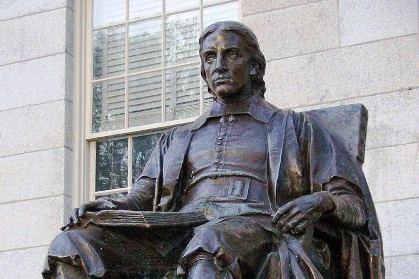 Eine Statue eines sitzenden Mannes mit einem Buch. 4