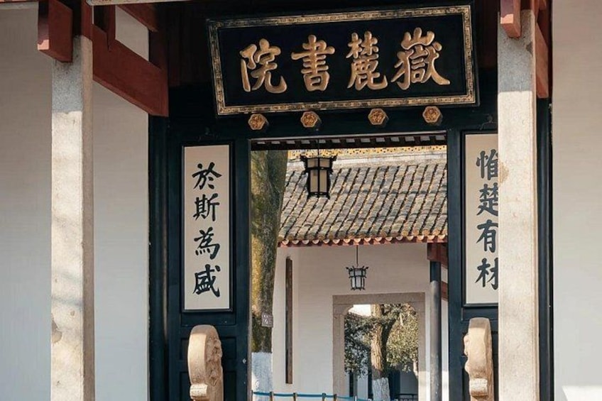 A traditional Chinese gate with inscriptions, a tiled roof, and stone pillars. 3