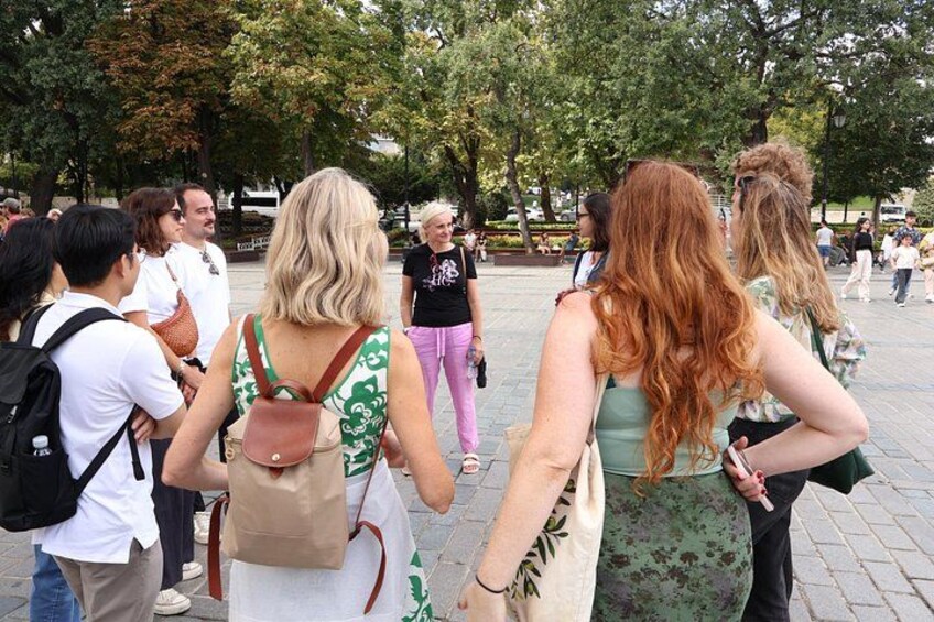 A group of people standing in a public square with trees in the background. 2