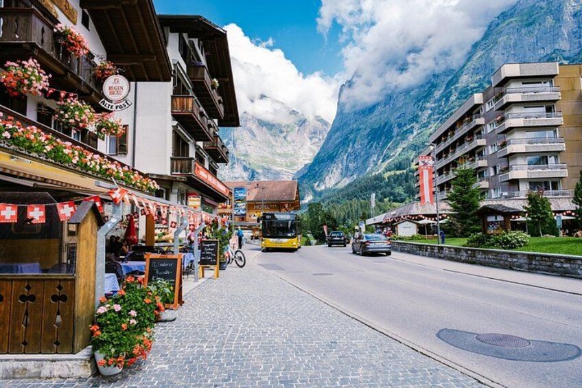 A mountain town with a yellow bus, wooden buildings, and a mountain backdrop. 2