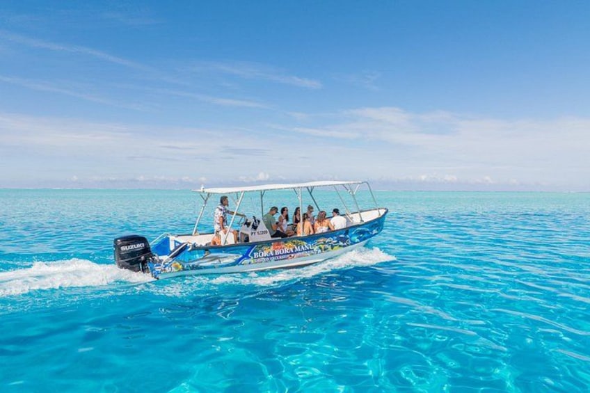 A boat with people on it, moving through clear blue water. 2