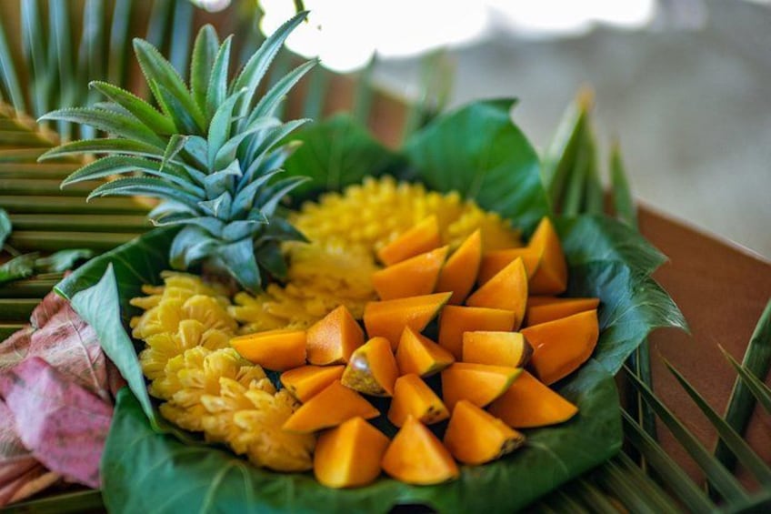 Fruta fresca con piña, mango y posiblemente papaya sobre una hoja de plátano. 2