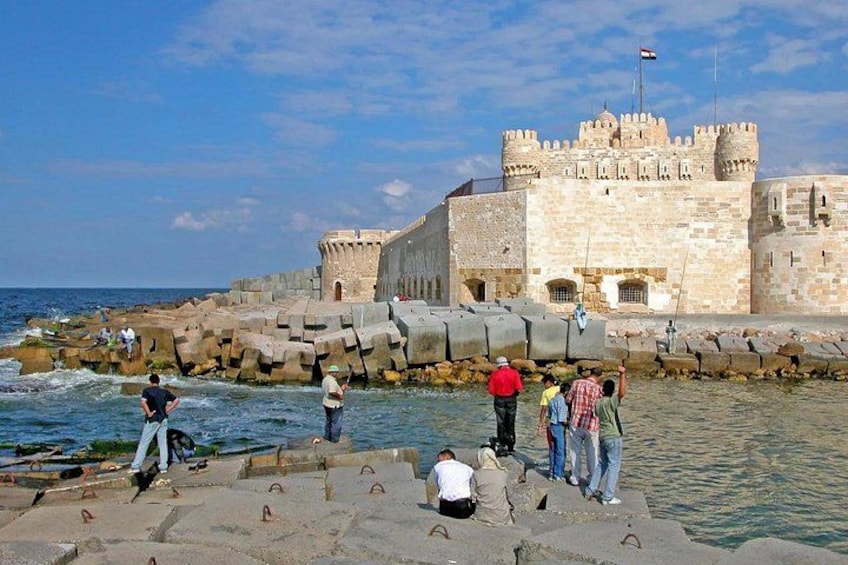 A coastal fortification with people near the water. 5