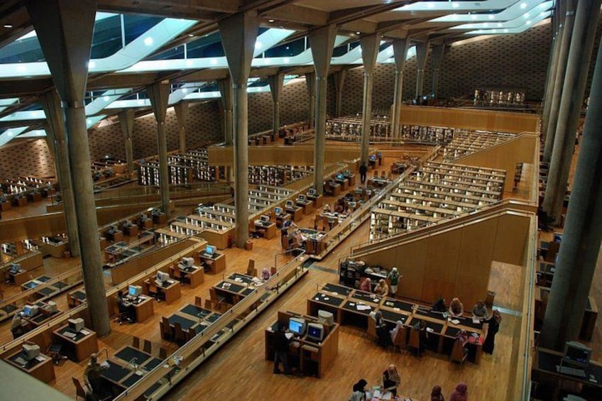 A large library with multiple levels and rows of bookshelves. 4