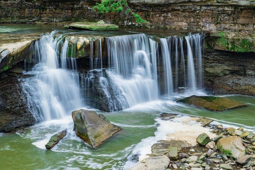 Una cascada que se precipita sobre rocas hacia una poza de agua. 3
