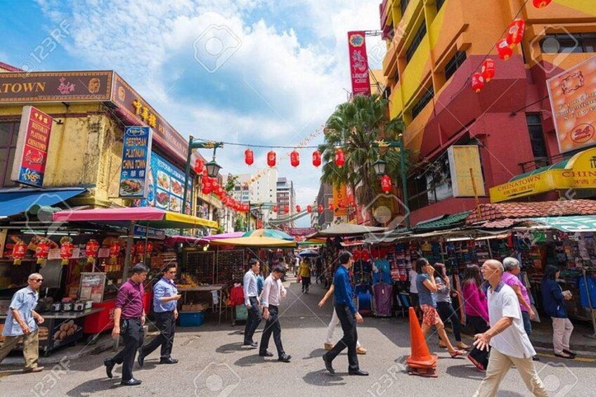 A bustling street market with vendors and shoppers. 2