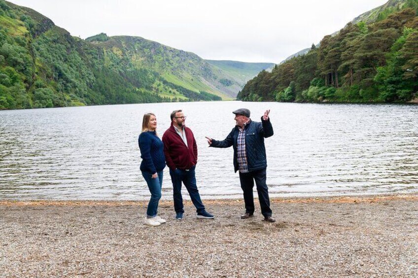 Three people standing by a lake with hills in the background. 5