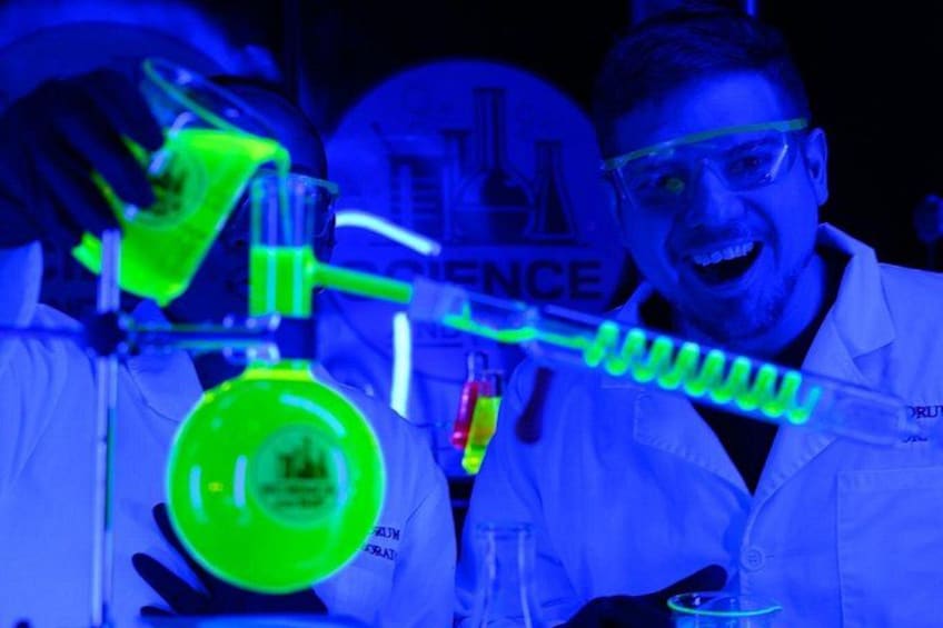 A person in a lab coat conducting a chemistry experiment with a beaker and test tubes. 4