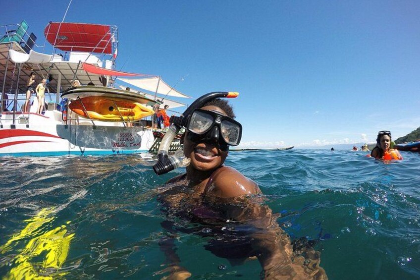A person snorkeling in the ocean with a boat in the background. 3