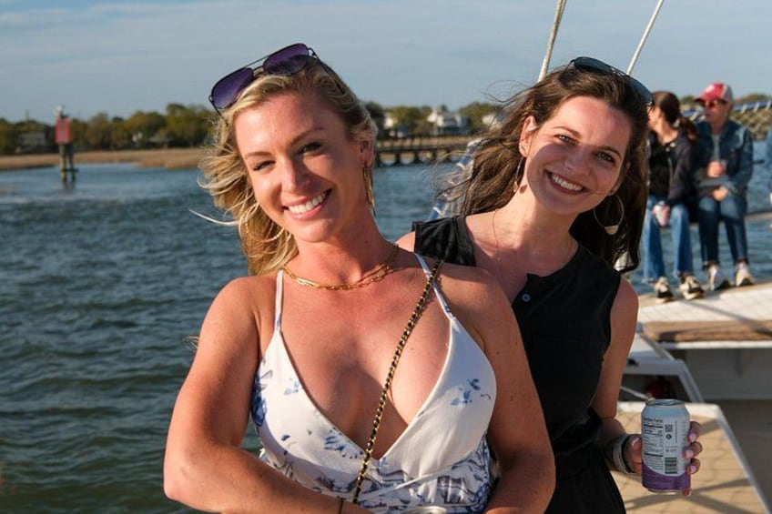Dos personas en un bote, agua al fondo y un muelle con gente a lo lejos. 5