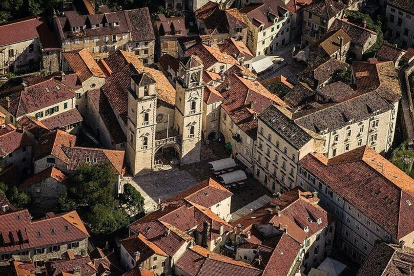 Una zona urbana con muchos edificios antiguos, una imponente torre de iglesia y una calle estrecha. 2