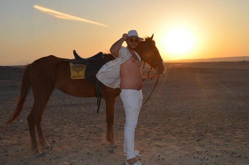 Una persona con un cavallo nel deserto al tramonto. 5