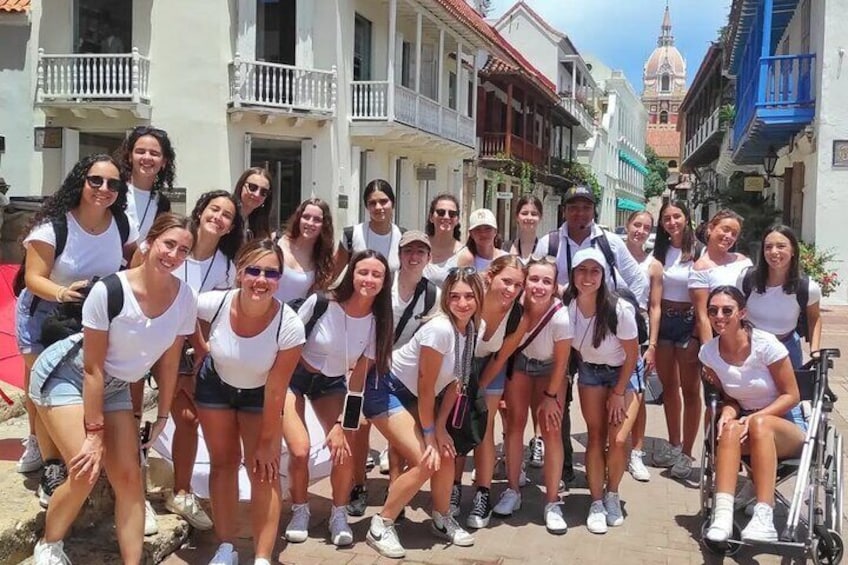 Un grupo de personas posando en una calle histórica con arquitectura colonial. 2