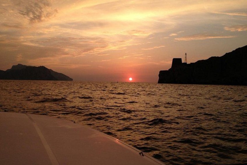 A sunset over a body of water with cliffs on either side. 1