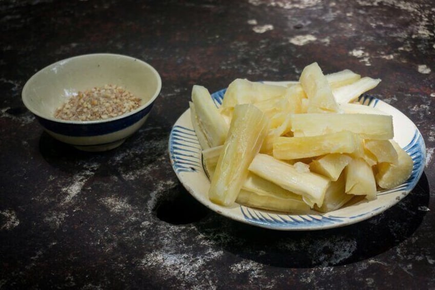 Un plato de rábanos blancos en rodajas y un tazón de semillas de sésamo sobre una superficie oscura. 4