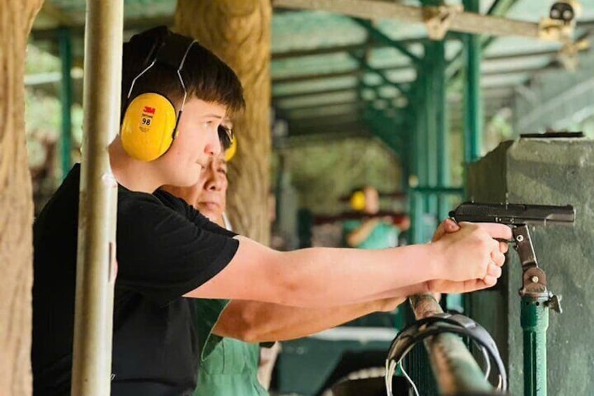 Una persona apuntando con una pistola a un blanco. 1