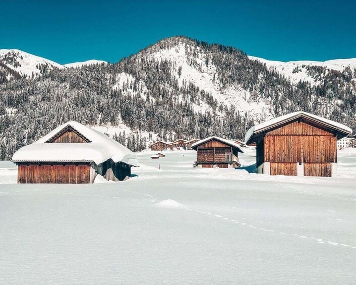 A snowy mountain landscape with wooden cabins. 4