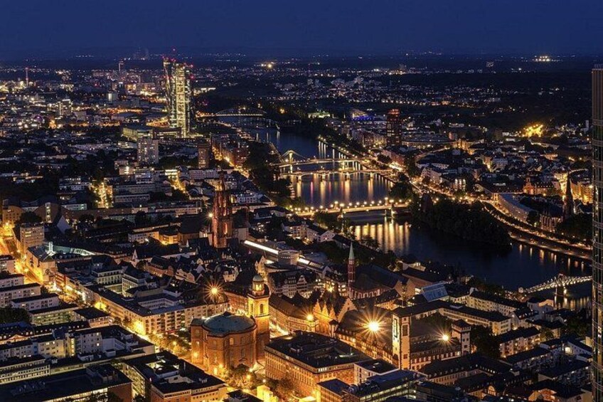 A cityscape at night with illuminated buildings, a prominent church, and a river. 3