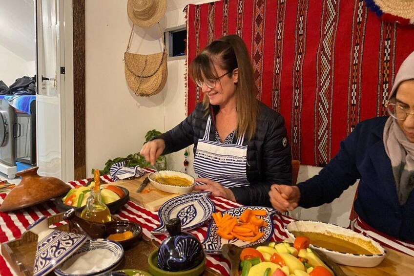 A dining table with various dishes, a hat on the wall, and a patterned curtain. 2