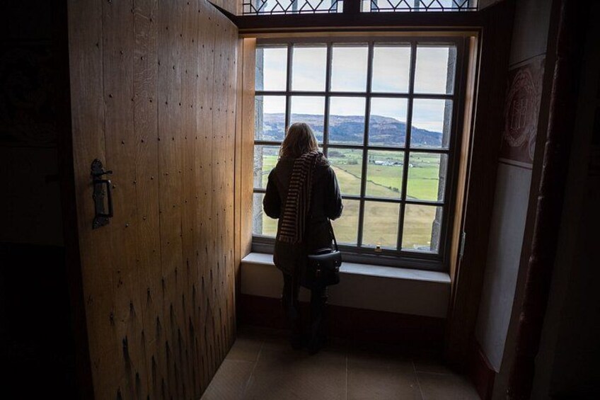 Une personne se tient près d’une fenêtre, d’où l’on peut admirer un paysage. 2