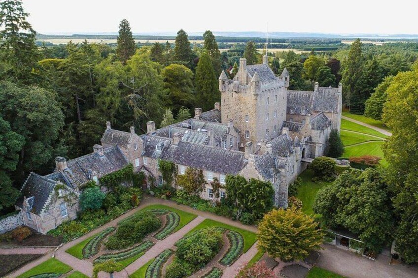 A castle surrounded by lush greenery and manicured gardens. 5