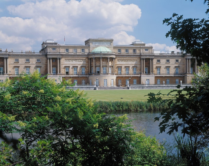 A large stately building with a central dome, surrounded by a well-manicured lawn and a body of water. 2