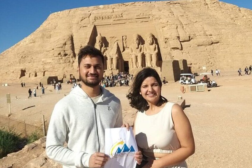 En stor sandstensbygning med hieroglyffer og statuer, omgivet af turister. 5