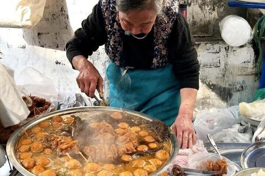 A person cooking in a large pot with meat and vegetables. 2