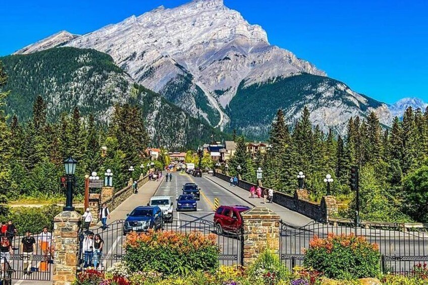 Une route de montagne avec des voitures, un pont piétonnier et une porte en pierre. 2