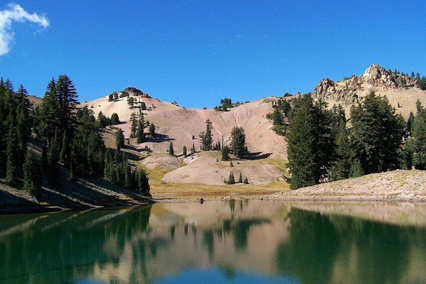 Un paysage de montagne avec un lac qui reflète le ciel et les arbres. 5