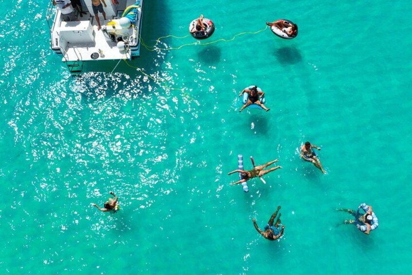 Un bote con gente nadando en aguas turquesas. 2