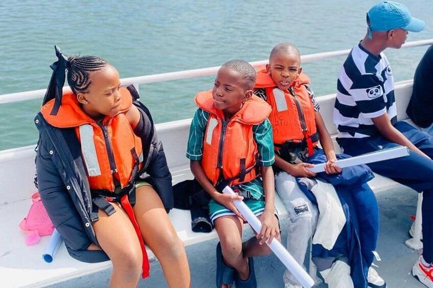People on a boat wearing life jackets. 5