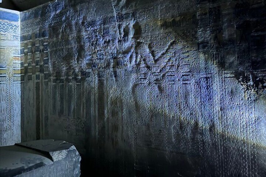 Una pared con textura y patrones tallados, además de inscripciones. 3