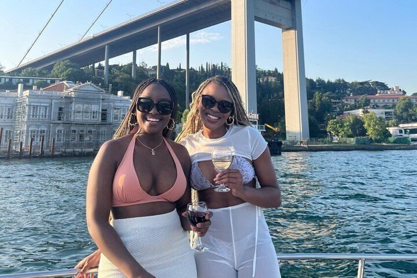 Two people on a boat with a bridge and buildings in the background. 5