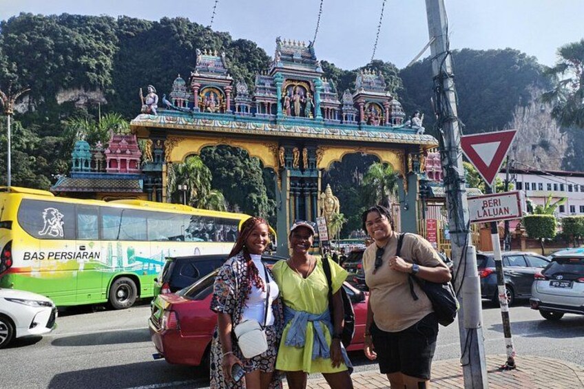 A temple with colorful architecture, a yellow bus, and a red car. 3