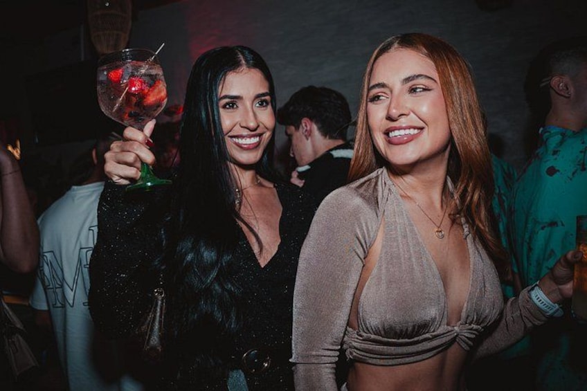 Two people holding drinks at a social event. 2