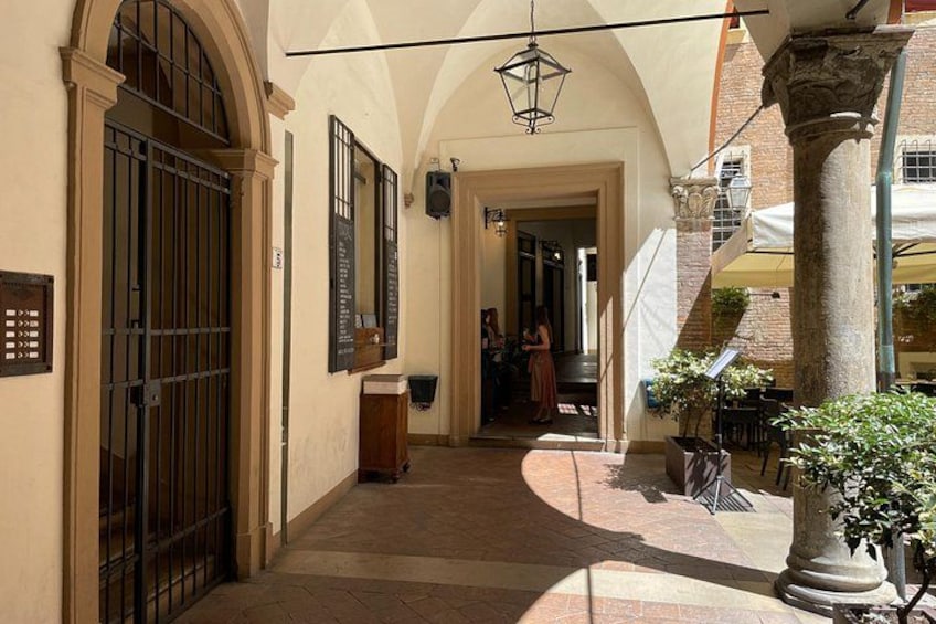 Un patio con piso de baldosas, una reja metálica y una columna con una planta. 5