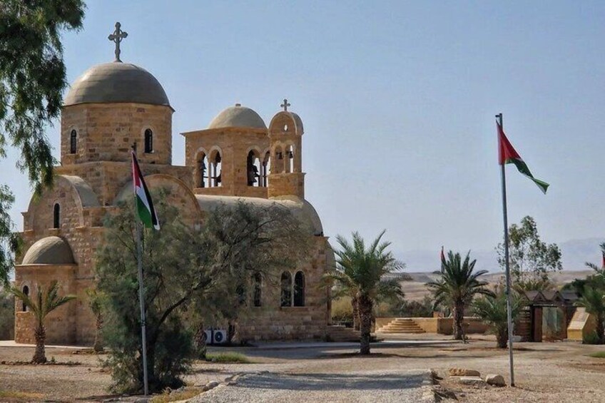 Una iglesia de arquitectura con cúpulas, banderas y un paisaje desértico. 3