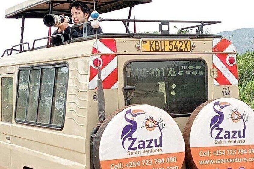 A safari vehicle with a license plate KBU 542X, branded with Zazu Safari Ventures. 1