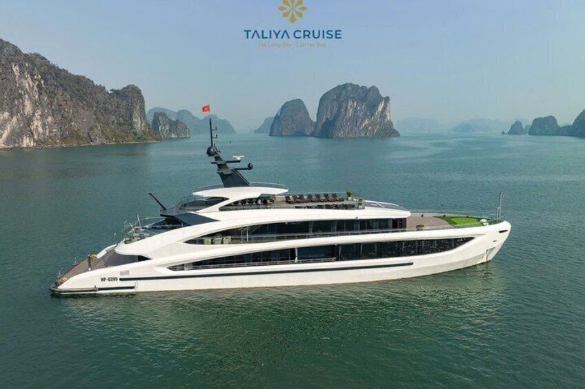 A large white yacht with multiple decks sailing on calm waters, surrounded by rocky islands. 1