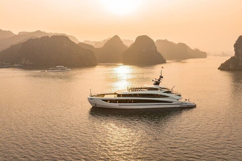 A white yacht on calm waters with a mountainous coastline in the background. 2